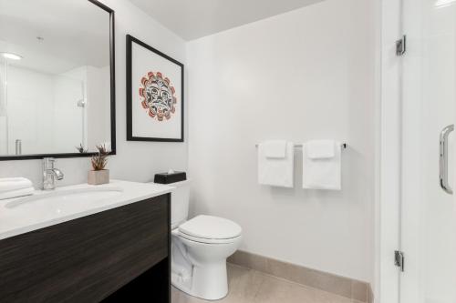 biała łazienka z toaletą i umywalką w obiekcie WorldMark Vancouver The Canadian w mieście Vancouver