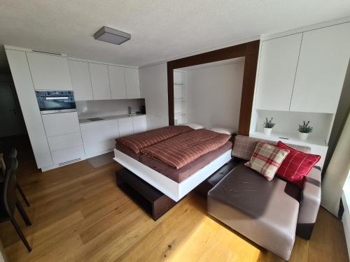 ein Schlafzimmer mit einem Bett und einem Sofa in der Unterkunft Haus Allod 205 in Lenzerheide