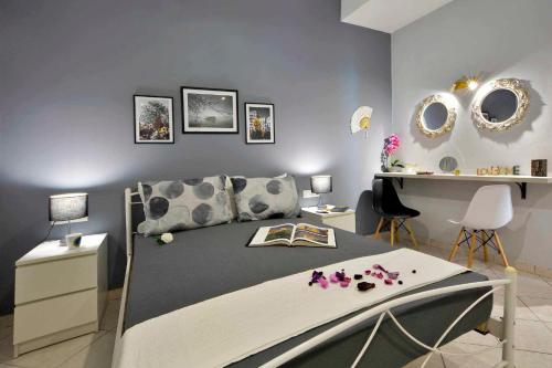 a bedroom with a bed and a desk and mirrors at Casa Mia Apartment in Corfu