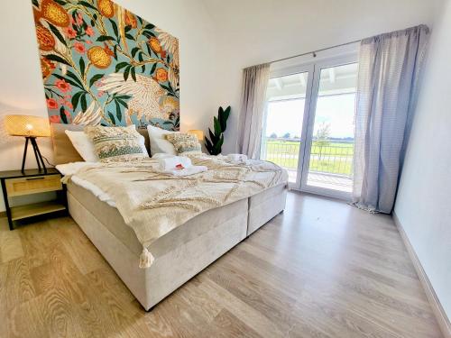 a bedroom with a large bed and a large window at SiOUX: Penthouse „BOHO“ mit traumhaftem Ausblick in Leutkirch im Allgäu