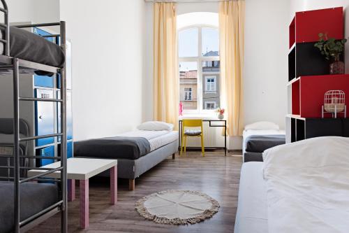 ルブリンにあるホステル クロレフスカの二段ベッドとソファが備わるドミトリールームです。