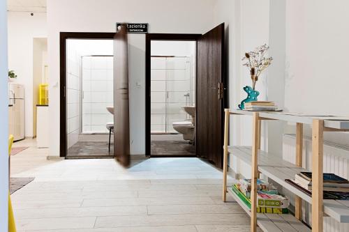 łazienka z drzwiami otwieranymi na łazienkę z toaletą w obiekcie Hostel Królewska w mieście Lublin