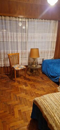 a bedroom with a bed and a chair and a table at Zarate al Rio in Zárate