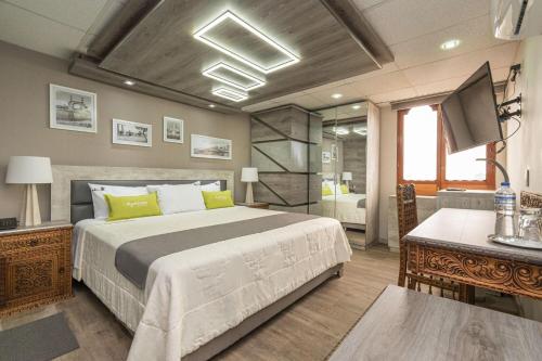 1 dormitorio con 1 cama grande y baño en Hotel El Marqués, en Lima