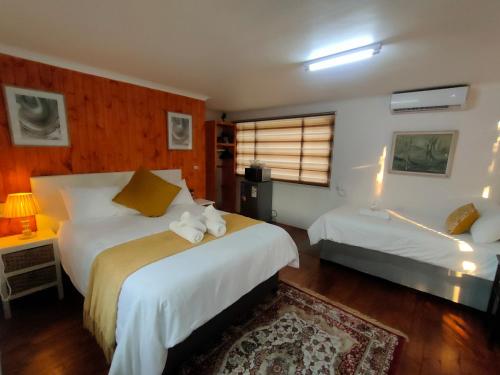 a hotel room with two beds and a window at Lipizzaner Lodge - Kyalami, Midrand in Kyalami