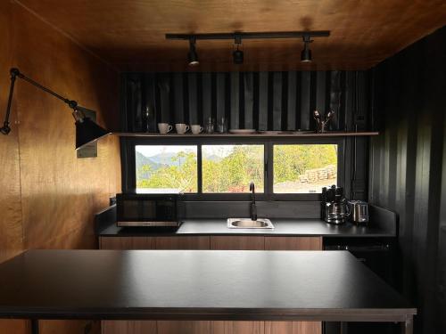 a kitchen with a black counter and a window at Nomada Republic Hotel El valle in Antón