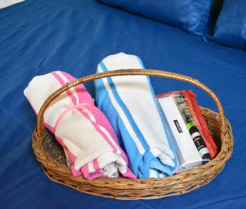 a basket with towels and other items on a bed at Housetel in Jaipur
