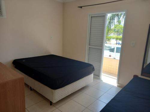 a bedroom with a bed and a sliding glass door at Apartamento de Frente para o Mar in Ubatuba