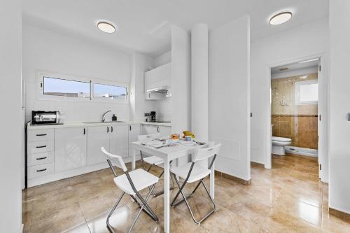 eine weiße Küche mit einem weißen Tisch und Stühlen in der Unterkunft Apartamento Arcoiris in Arrieta