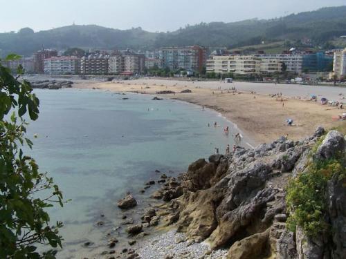 a beach with a group of people in the water at Jumeke Home in Castro-Urdiales