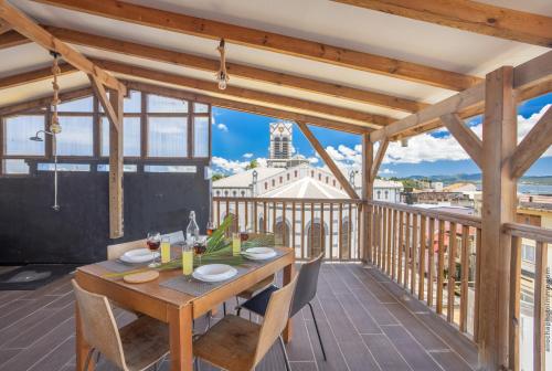 una mesa de madera en un balcón con vistas a la ciudad en Carré d'as en Fort-de-France