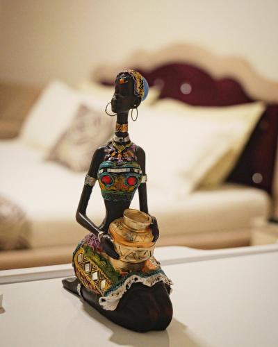a figurine of a woman with a bowl on a table at Hotel Vila Dedej in Durrës