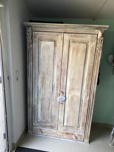 a wooden cabinet in the corner of a room at Romantisch Tiny Gardenhouse in beautiful garden in Zandvoort