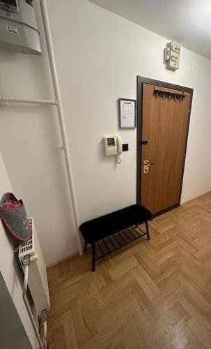 um corredor com uma porta e um banco num quarto em Greywood relax apartment em Zagreb