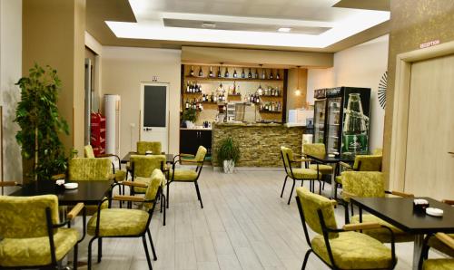 a restaurant with tables and chairs and a bar at Hotel Vila Dedej in Durrës