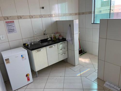 eine kleine Küche mit Spüle und Kühlschrank in der Unterkunft Apartamento Centro Alfenas in Alfenas
