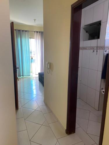 a bathroom with a shower and a tiled floor at Apartamento Centro Alfenas 03 in Alfenas