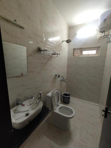 a white bathroom with a sink and a toilet at Cloud & Mist Inn, Kotagiri in Kotagiri
