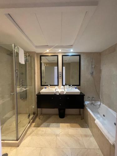 een badkamer met 2 wastafels, een bad en een douche bij LUXURY Casares del Mar DBJ11 in Casares