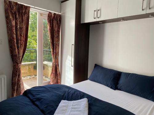 a bedroom with a bed and a large window at Two Bedroom apartment with river view in London