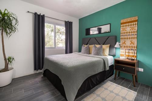 1 dormitorio con cama y pared azul en Apartamento acogedor y minimalista. en Quetzaltenango