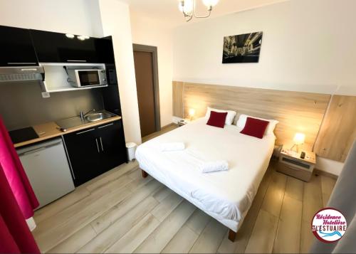a small room with a bed and a kitchen at Résidence Hôtelière de l'Estuaire in Le Havre