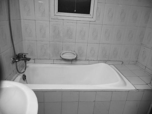 a white bath tub in a bathroom with a window at 05 Burjuman metro stations Unisex Hostel Private room - 05 in Dubai