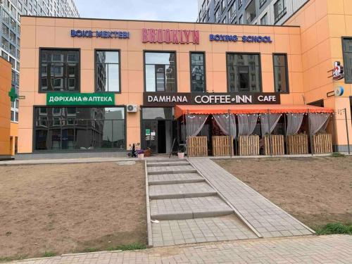 a building with a coffee shop in front of it at Апартаменты на Туране в Алтын Шар in Taldykolʼ