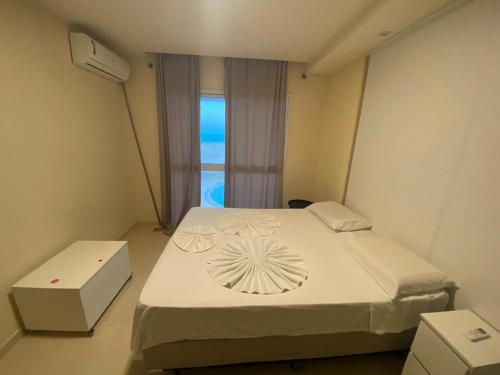 a bedroom with a bed and a window with the ocean at Vilas Na Praia Residence Condomínio in Canoa Quebrada