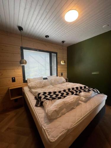 a large bed in a room with a green wall at Himos Villa Golden in Jämsä