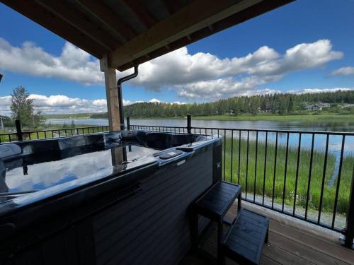 a hot tub on a deck with a view of a lake at Himos Villa Golden in Jämsä