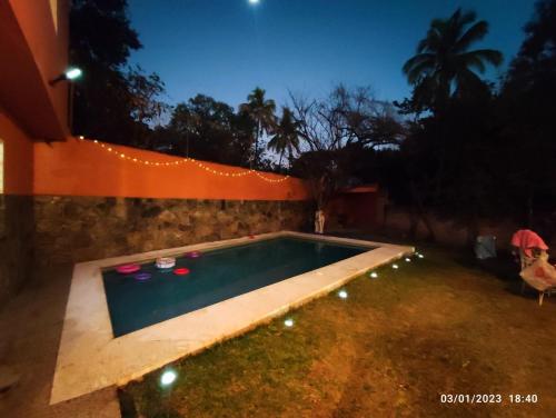 una piscina en un patio por la noche con luces en Casa Alpuyeca, en Alpuyeca