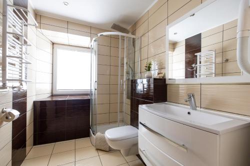ein Bad mit einem Waschbecken, einem WC und einem Fenster in der Unterkunft Gasthof Durigon in Ramingstein