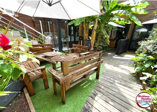 - une terrasse avec 2 bancs en bois et un parasol dans l'établissement Résidence Hôtelière de l'Estuaire, au Havre