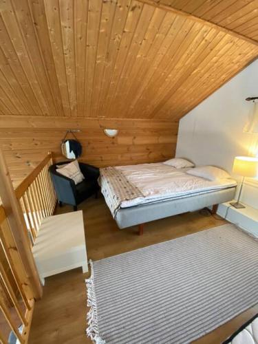 Cette chambre dispose de deux lits et d'un plafond en bois. dans l'établissement Himoshuvi 2, à Säyrylä