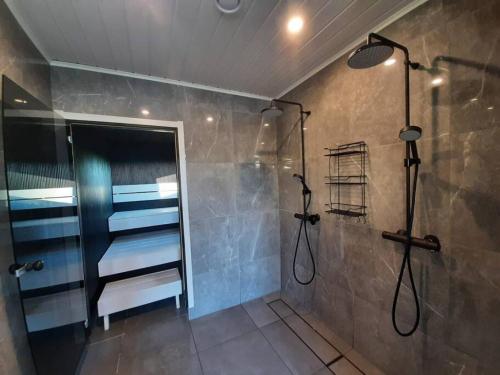 ein Bad mit einer Dusche und einer Glastür in der Unterkunft Villa Pussilanranta Himos in Jämsä
