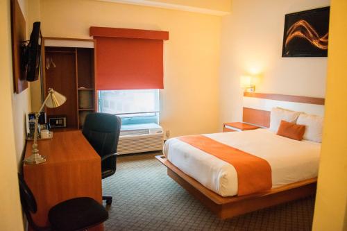 a hotel room with a bed and a desk at Los Herederos Hotel Piedras Negras in Piedras Negras