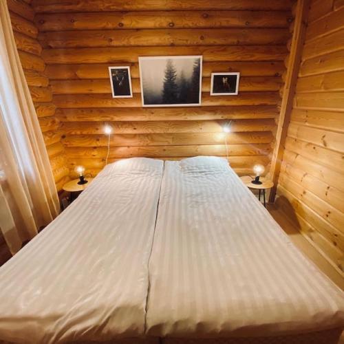 a bedroom with a bed in a log cabin at Havupirtti Himos in Jämsä
