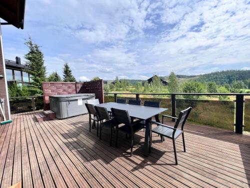 a patio with a table and chairs on a deck at Himos Aurinkopaikka 3 in Jämsä