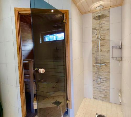 a shower with a glass door in a bathroom at Himos Aurinkopaikka 3 in Jämsä
