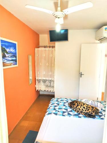 a bedroom with a bed in a room with orange walls at Pousada Atobá Juquehy Apartamentos in Juquei
