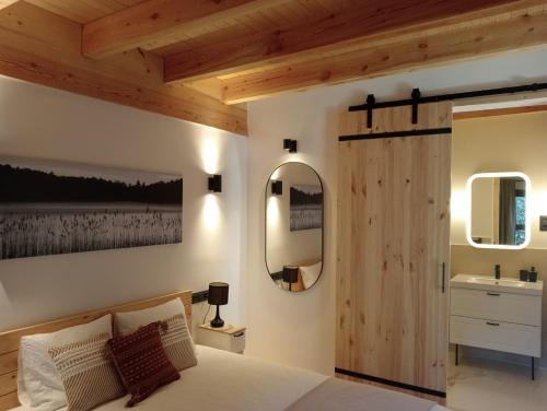 Schlafzimmer mit Holztür und Waschbecken in der Unterkunft Jardín Las Secuoyas in Becerril de la Sierra