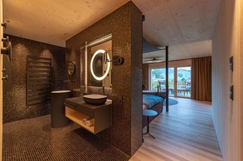 La salle de bains est pourvue d'un lavabo et d'un miroir mural. dans l'établissement Bio-Hotel Oswalda-Hus, à Riezlern