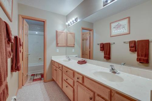 a bathroom with a sink and a large mirror at Amalia Mountain Getaway with Deck, Fireplace! 