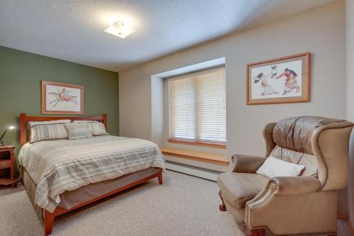 a bedroom with a bed and a chair and a window at Amalia Mountain Getaway with Deck, Fireplace! 