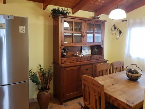 a kitchen with a wooden table and a refrigerator at Casa Gorreta in Guinea