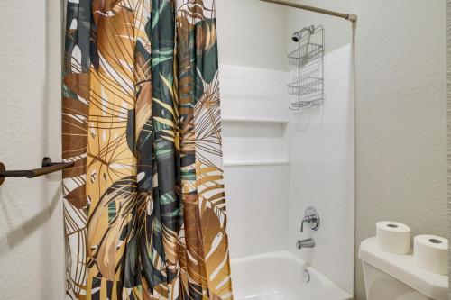 a bathroom with a shower curtain and a toilet at Houston Home with Private Yard Near The Galleria in Hot Wells