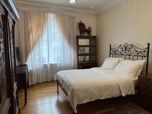 Schlafzimmer mit einem Bett und einem Fenster in der Unterkunft Апартаменты на Бориса Гринченка in Kiew