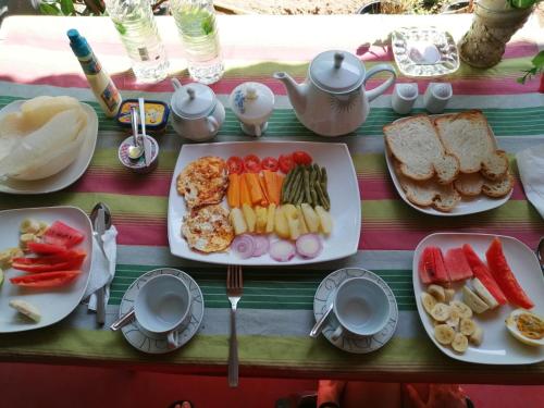 a table with a plate of food with fruits and vegetables at Kavidi Villa Home Stay in Tangalle