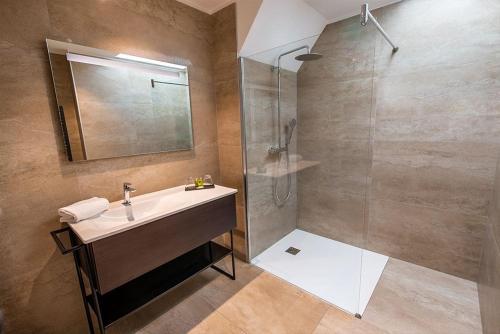 a bathroom with a sink and a shower at Hotel Haras De La Potardiere in Crosmières